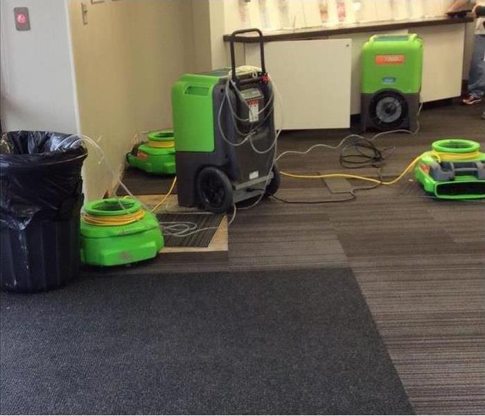 Air movers and a dehumidifier drying out a commercial building